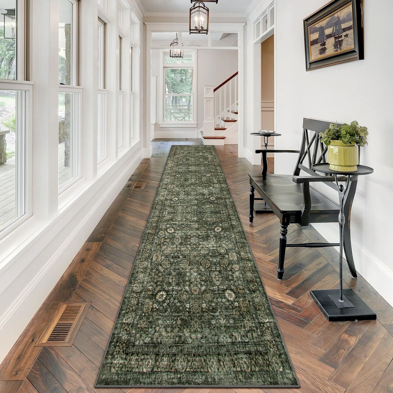 Traditional green hallway runner rug with subtle vintage patterns placed in a bright, modern entryway with wooden flooring and white walls.