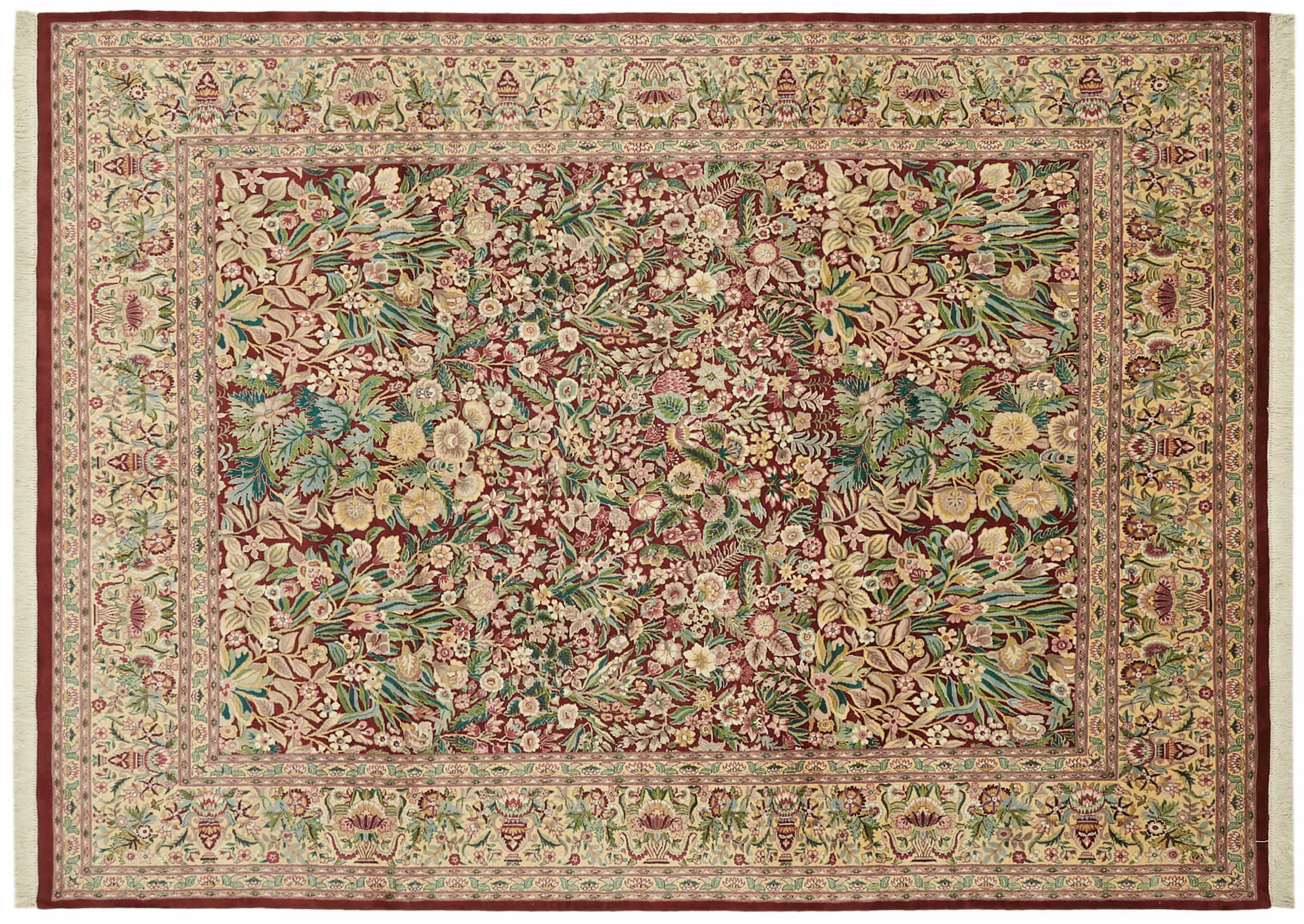 Intricately designed Oushak-style rug with a rich, detailed floral pattern. The central field of the rug is dominated by a dense array of flowers and foliage in various shades of green, blue, yellow, and pink, set against a deep red background.