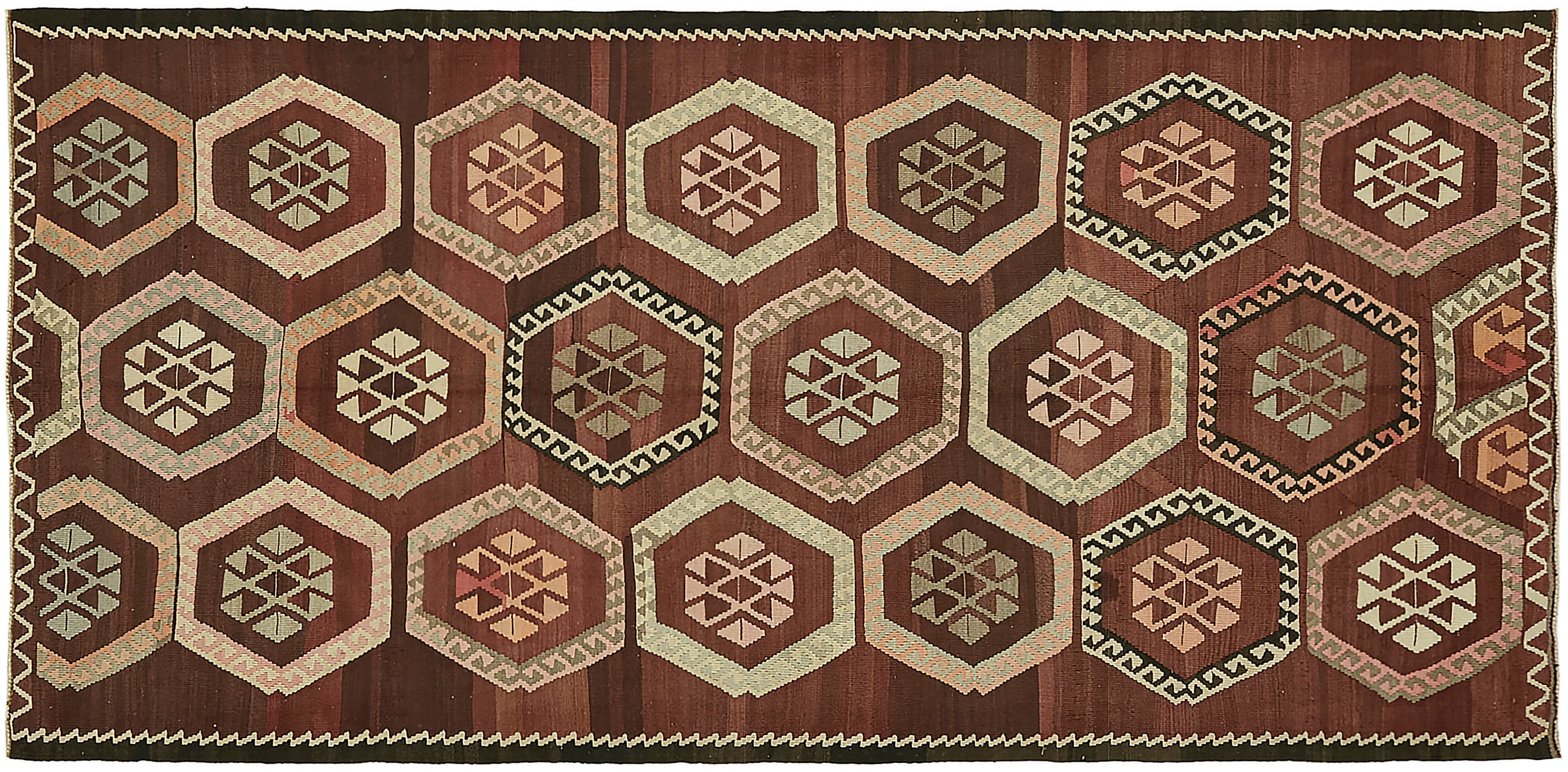 Traditional Anatolian flatweave kilim rug featuring repeating hexagonal medallions with geometric motifs in earthy tones of red, brown, and beige, showcasing its authentic handwoven texture.