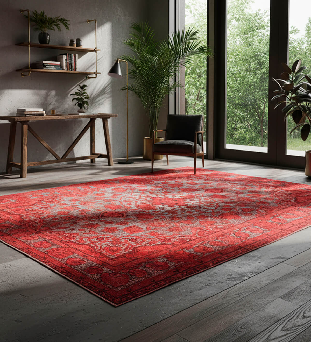 A vibrant red overdyed vintage area rug in Turkish Oushak style, set against a modern industrial backdrop. The large rug contrasts beautifully with the concrete walls, dark wood floors, and minimalist furniture in this sunlit home office. Natural light, lush indoor plants, and a rustic wooden desk complete the contemporary, eclectic look