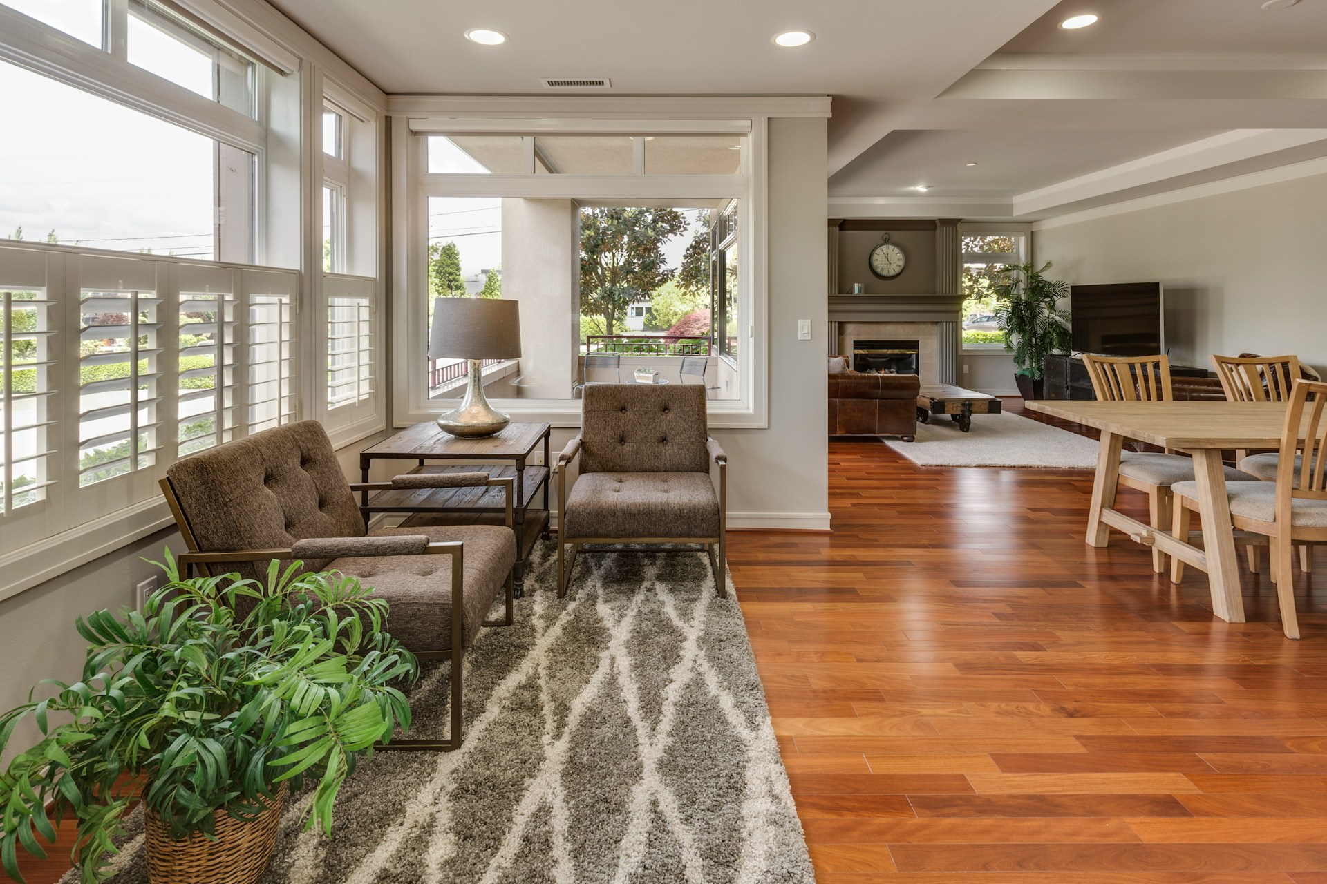 The striking grey Moroccan carpet in open weave with white stripes is a visually appealing focal point in the room. The tastefully decorated room benefits from an abundance of natural light. The furniture above the carpet is strategically positioned to make the most of the views from the windows. Opposite is an elegant wooden dining table.