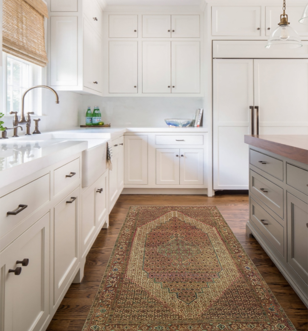 Hand-knotted Persian runner rug with intricate floral pattern in a white, high-end farmhouse kitchen. Ideal for adding warmth and vintage style to a high-traffic galley space.