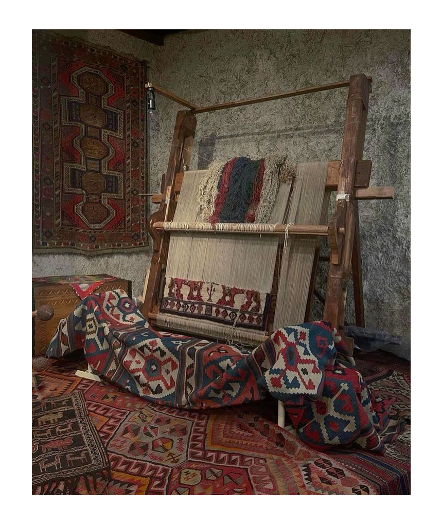 A traditional hand-knotted rug in progress on a wooden weaving loom, showcasing the intricate craftsmanship and authentic colors of the textile