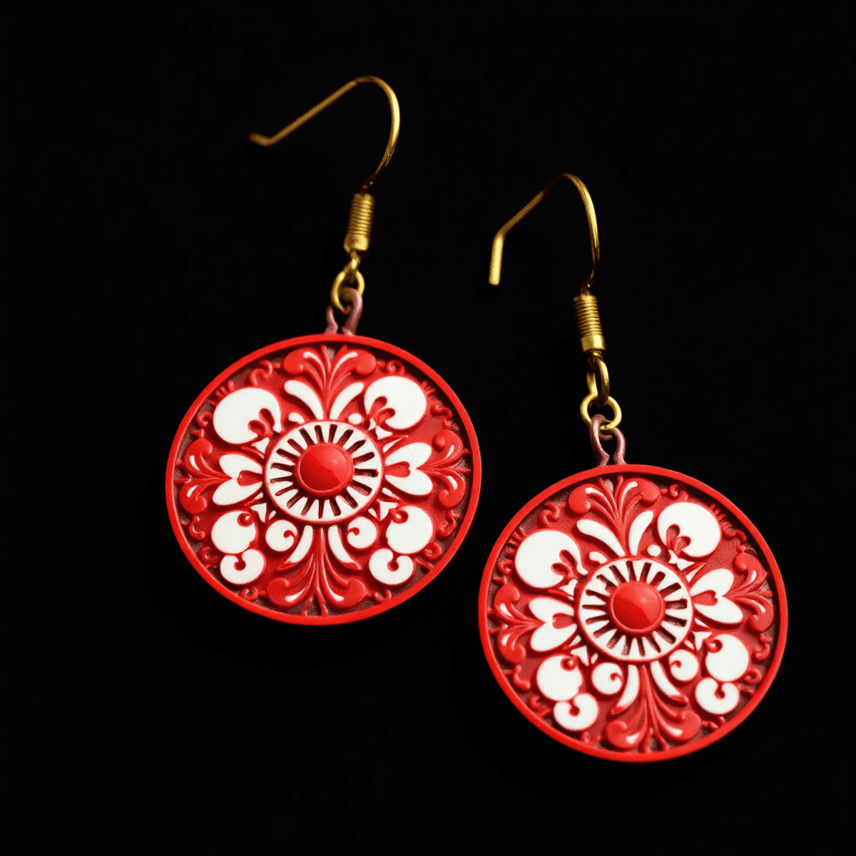 Close-up of vibrant red and white hanafuda-style earrings with intricate traditional Japanese metalwork and bold patterns on a dark background.