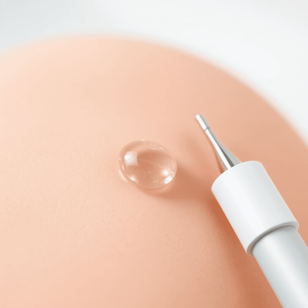 Hyaluronic Acid Serum: 5 Powerful Microneedling Tips for Outstanding Results 1 Close-up of a glossy hyaluronic acid serum droplet on smooth skin beside a clean microneedling device with soft natural lighting and pastel clinical background.