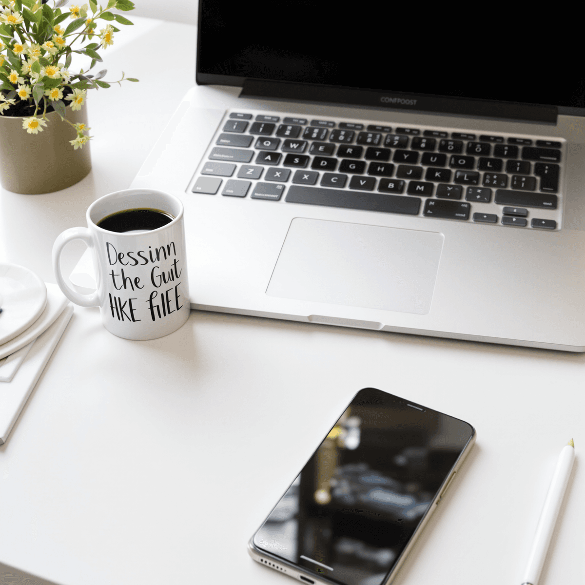 Kantor rumah modern yang cerah dengan laptop, smartphone, dan cangkir kopi di meja, melambangkan bisnis online dan penulisan konten.