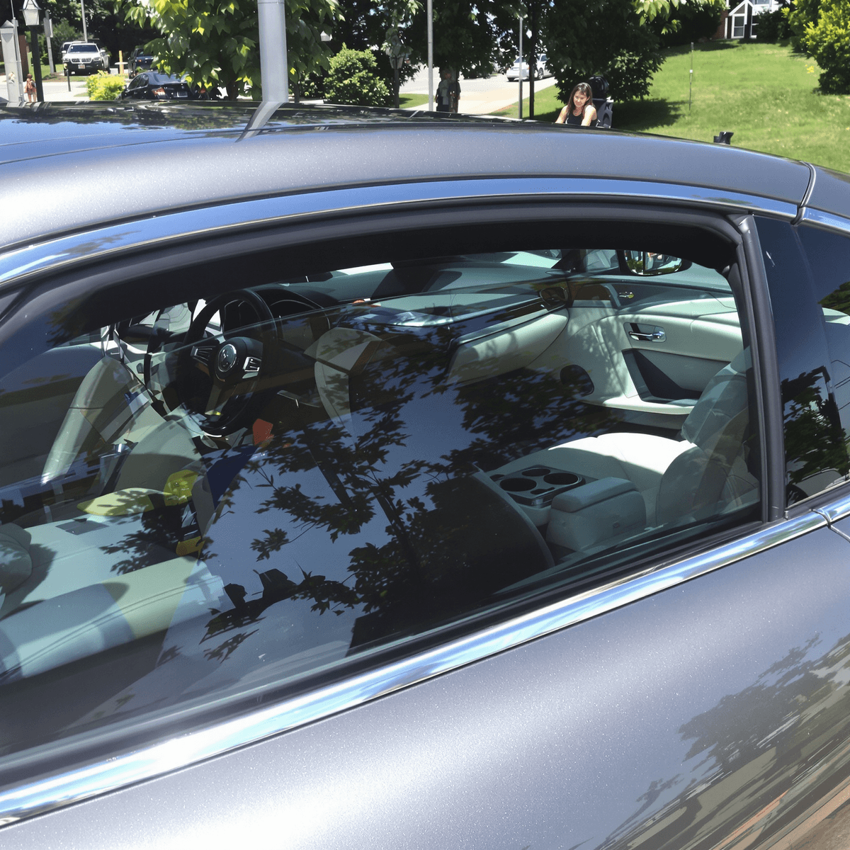 A shiny, freshly detailed car parked in a scenic outdoor setting, with bright sunlight highlighting its gleaming exterior and pristine interior, surrounded by cleaning tools.