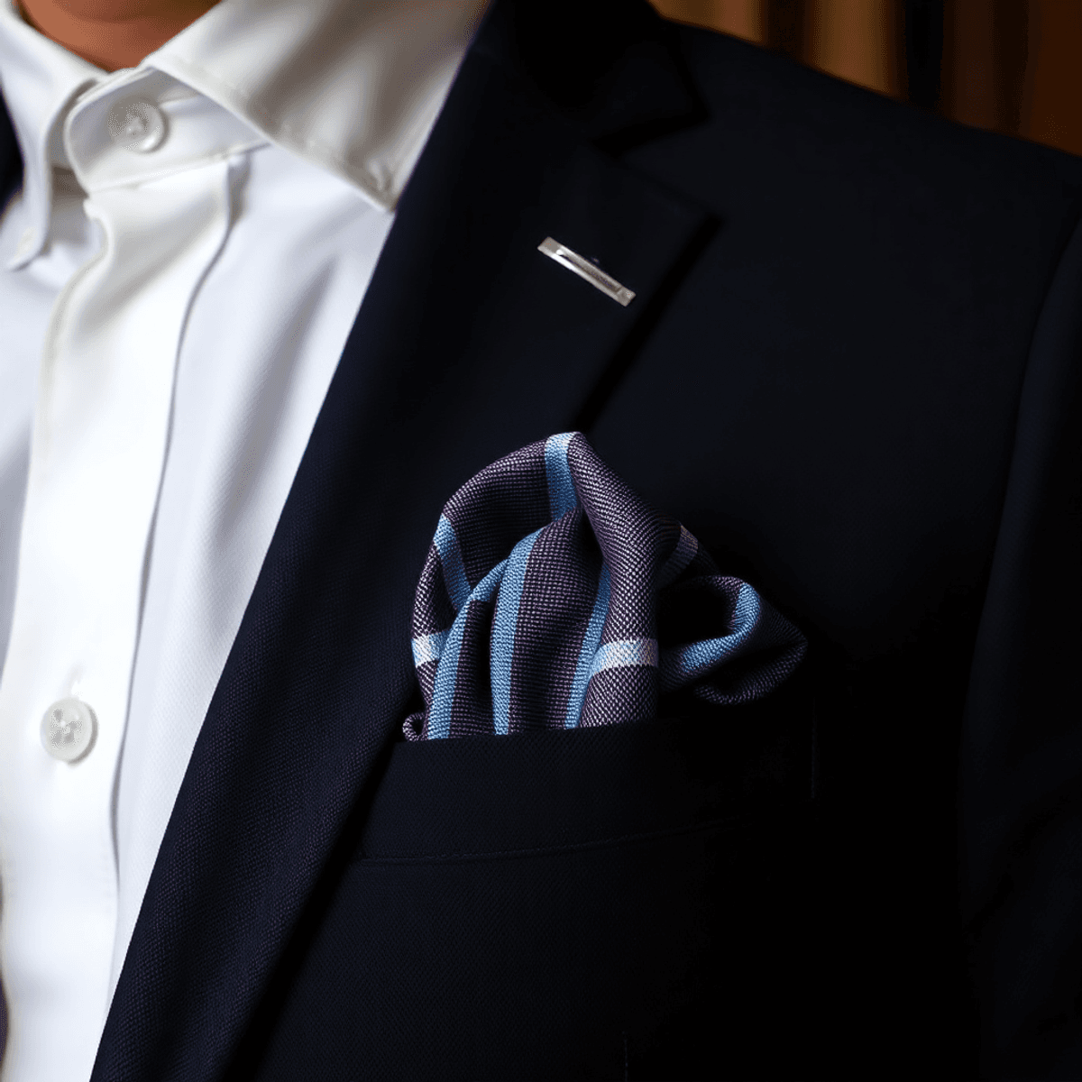 Un mouchoir de poche soigneusement plié dans la poche d'une veste sur mesure, se détachant sur un fond raffiné, dégageant une élégance intemporelle et une attention aux détails dans la mode masculine.