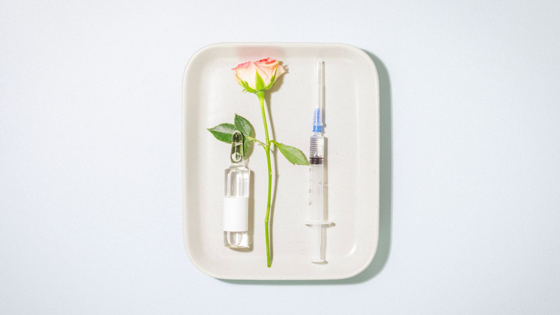 femme avec chapeau et crème solaire sur le visage