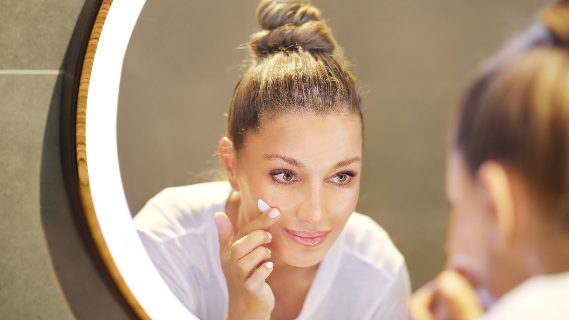 femme qui applique de la crème sur son visage