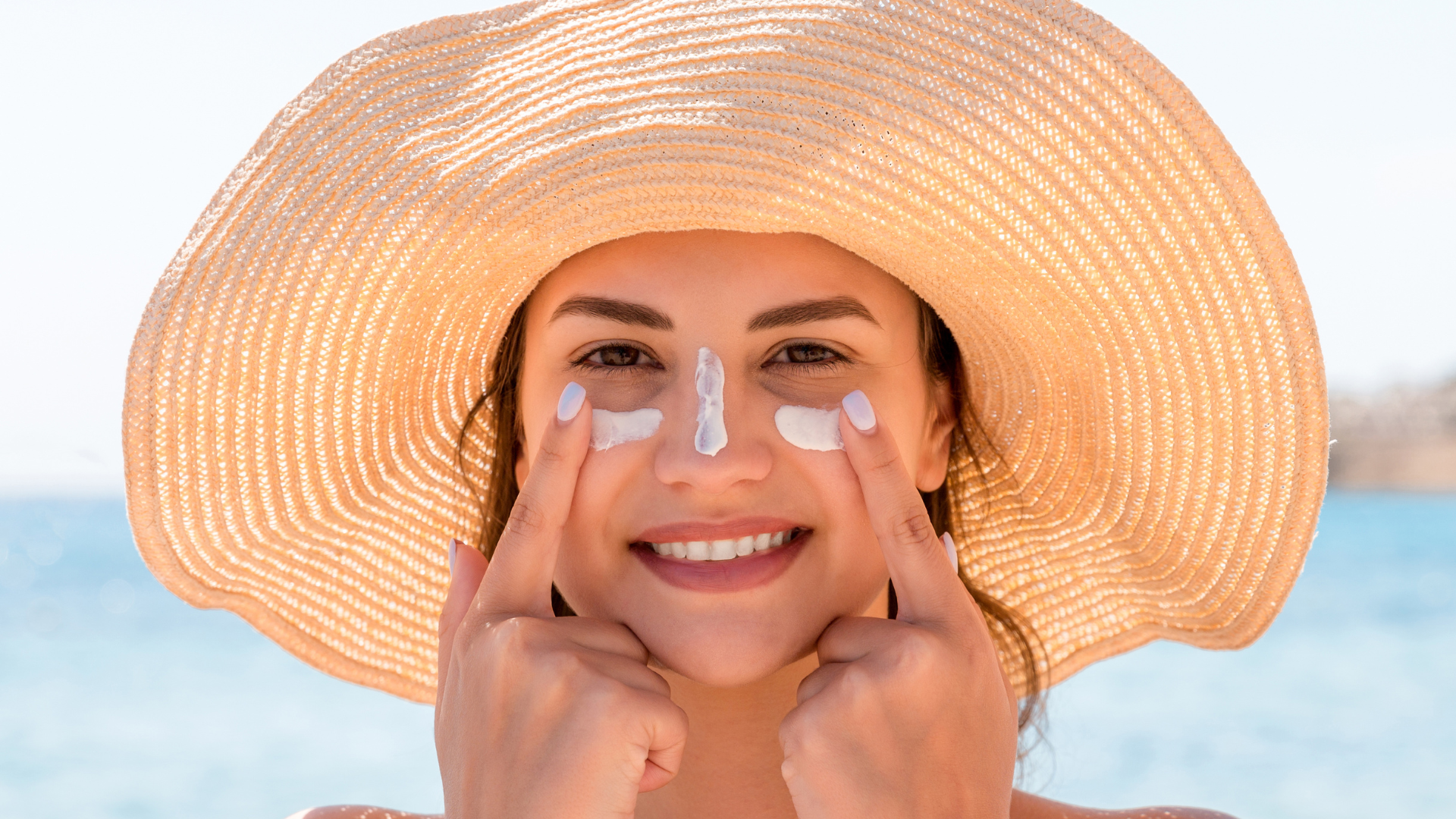 femme qui applique de la SPF crème solaire sur son visage pour prévenir signes de l'âge