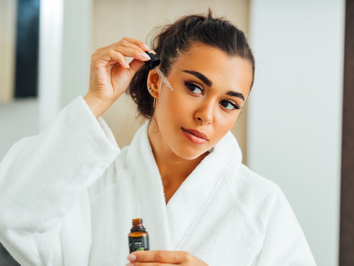 femme qui applique un sérum à l'acide hyaluronique