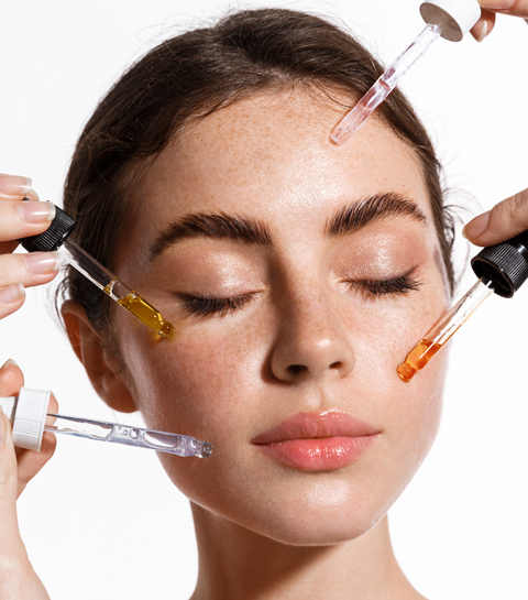 femme avec 4 pipettes de sérums autour de son visage