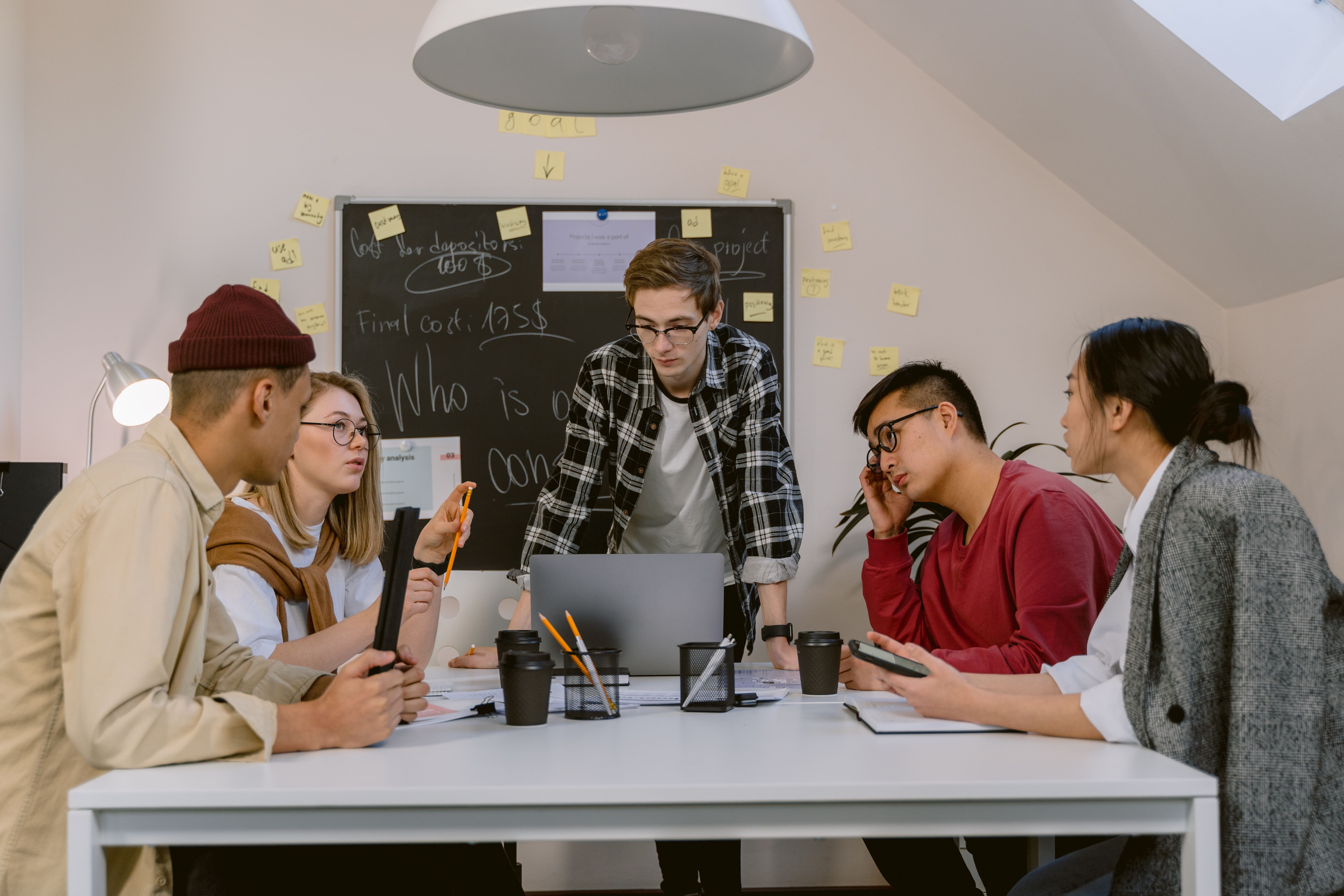 Students collaborating on a group project around a laptop