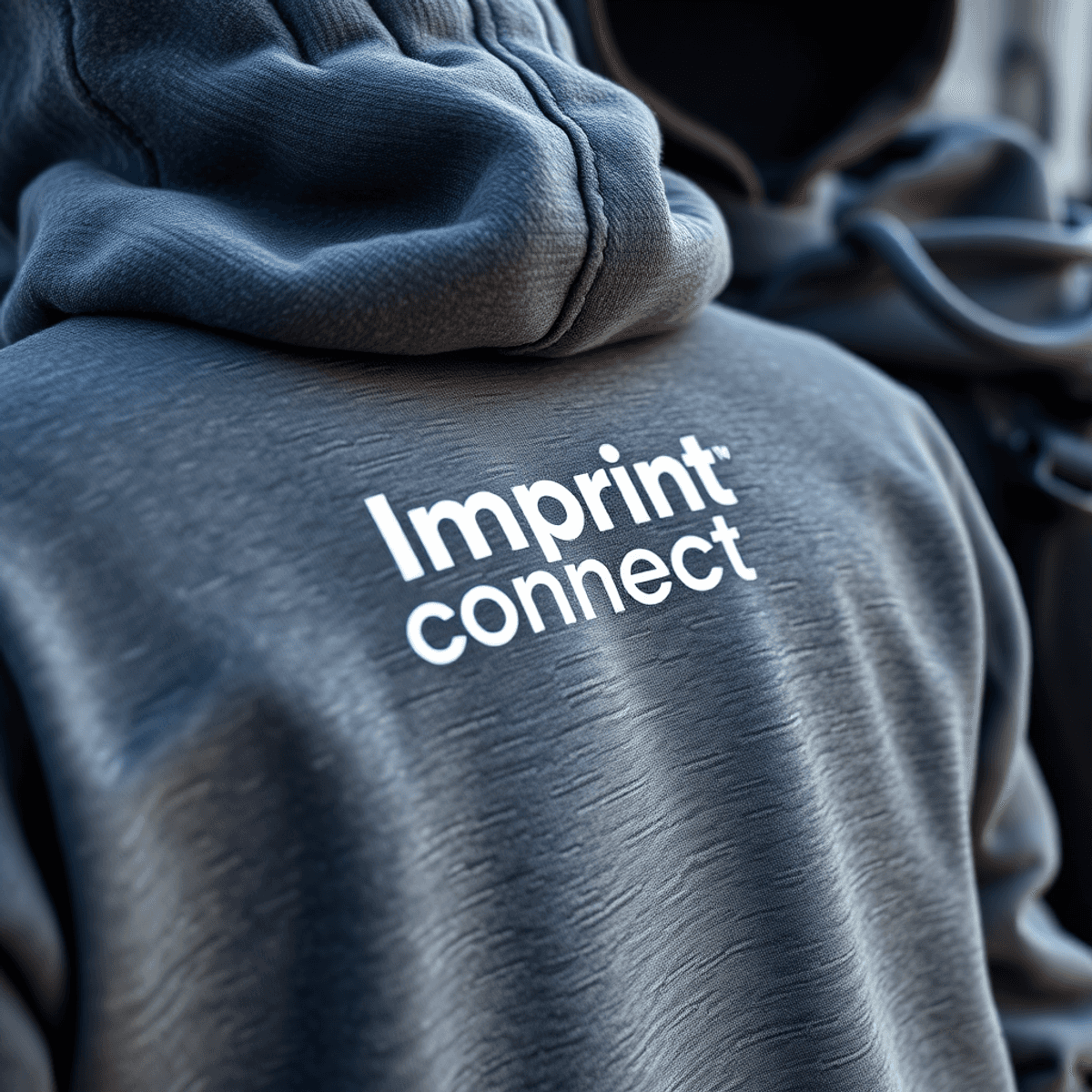 Close-up photograph of screen printed Imprint Connect design on hoodies, hats, jackets, and backpacks, showcasing textured fabric details, natural lighting, shallow depth of field, high resolution, realistic style.